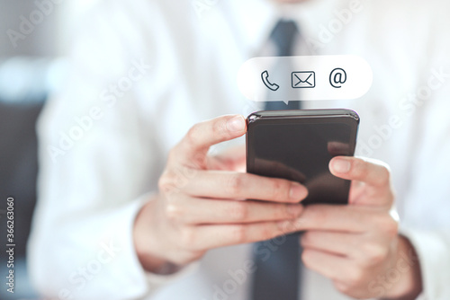 CONTACT US, Hand of Businessman holding mobile smartphone with ( mail,phone,email ) icon. cutomer support concept, copy space.