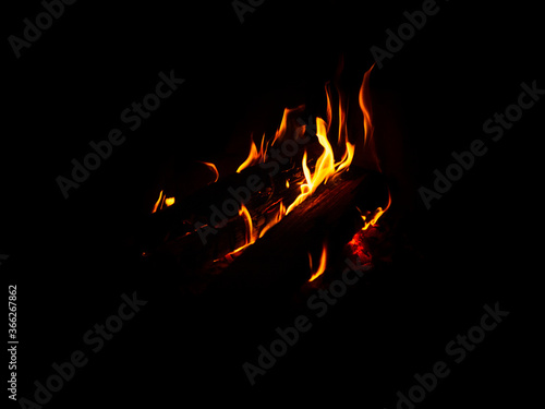 Fire and flame in the dark, with smoke and flames dancing on black background.