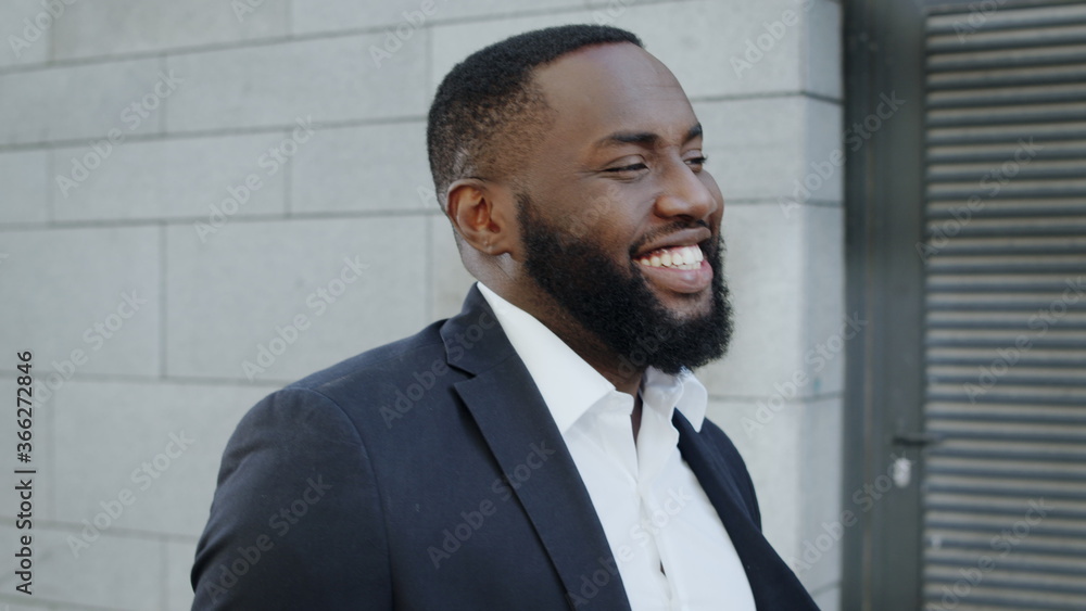 African businessman walking on city street. Smiling business man going outdoors African businessman walking on city street. Smiling business man going outdoors