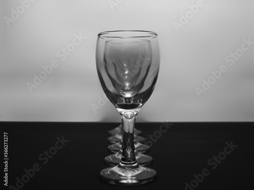 Row of empty wine glasses on table. Black and white concept