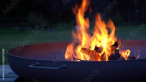 Iron fire pit and burning fire in a garden .  Campfire ,  close up image .