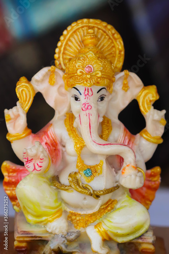 Colorful Painted Handcrafted Statue Of Indian Hindu Lord God Idol Ganesha Ganpati Made Of Earthenware Mud Clay Stone Or Rock For Worship Pooja Puja In Deepawali Deepavali Diwali And Chaturthi Festival