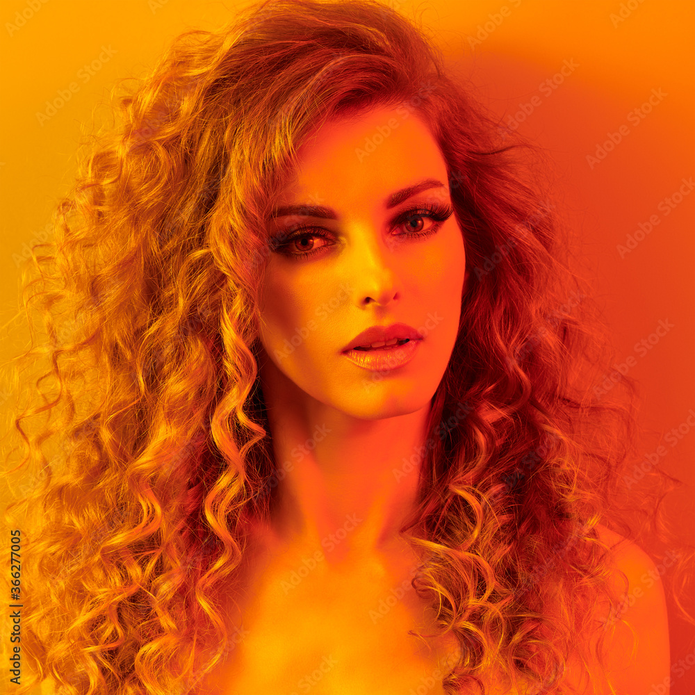 High Fashion. Woman in colorful neon gold light, make-up. Sexy blond girl, stylish curly hair, trendy makeup. Golden neon portrait. Creative beauty, fashionable model face, voluminous hairstyle High Fashion. Woman in colorful neon gold light, make-up. Sexy blond girl, stylish curly hair, trendy makeup. Golden neon portrait. Creative beauty, fashionable model face, voluminous hairstyle