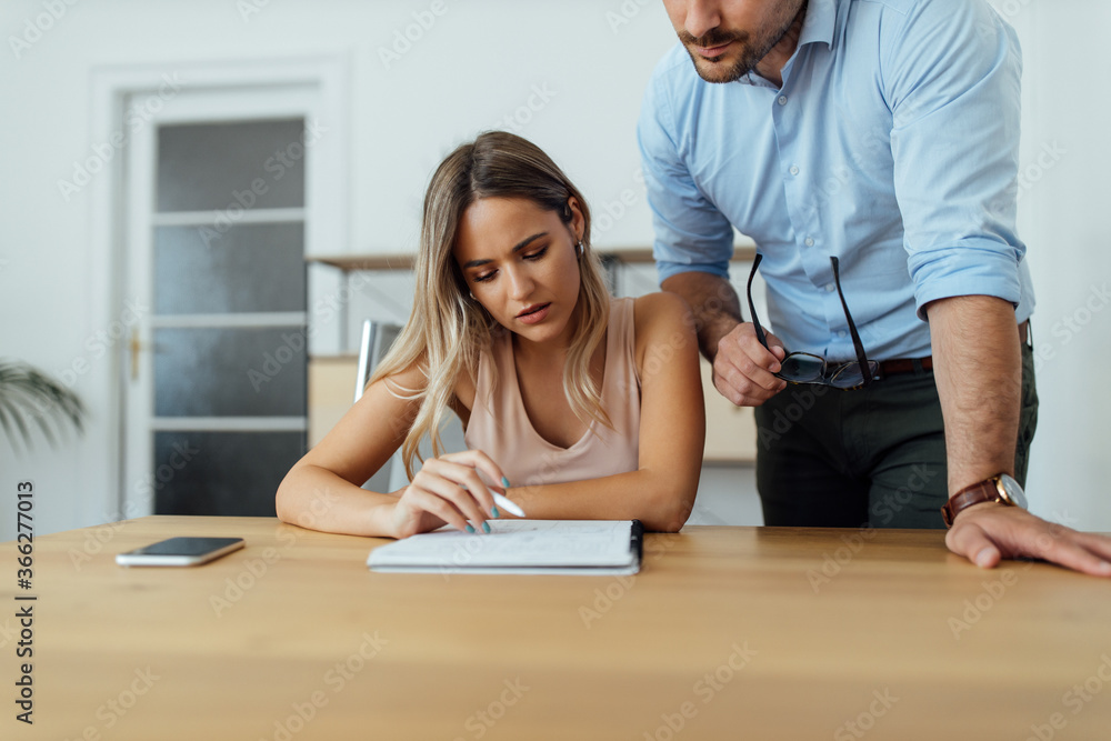 Problem solving. Two people looking at paper notebook, close-up. Problem solving. Two people looking at paper notebook, close-up.