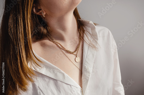Fotografie, Obraz Close-up young woman in white shirt wearing golden necklaces