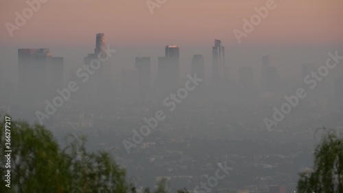 Highrise skyscrapers of metropolis in smog, Los Angeles, California USA. Air toxic pollution and misty urban downtown skyline. Cityscape in dirty fog. Low visibility in city with ecology problems