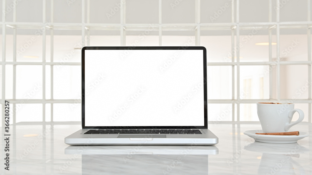 Mock up modern workspace desk and copy space with blank screen laptop and coffee cup on white table. Front view. concept work from home. Mock up modern workspace desk and copy space with blank screen laptop and coffee cup on white table. Front view. concept work from home.