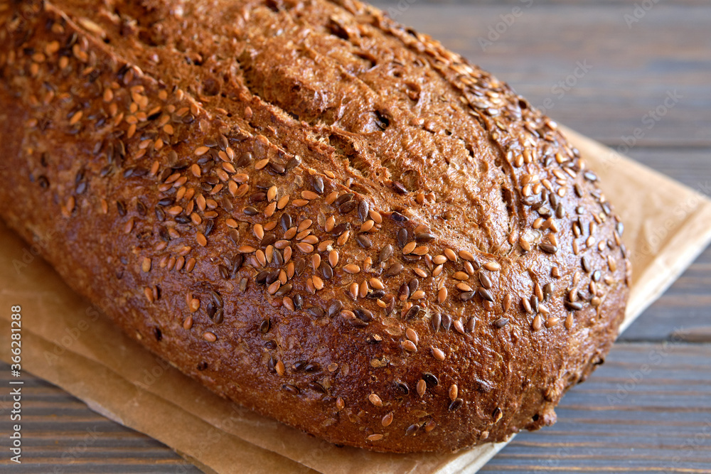 Fresh wholemeal bread with sunflower seeds close-up on an old wooden table. Fresh wholemeal bread with sunflower seeds close-up on an old wooden table.