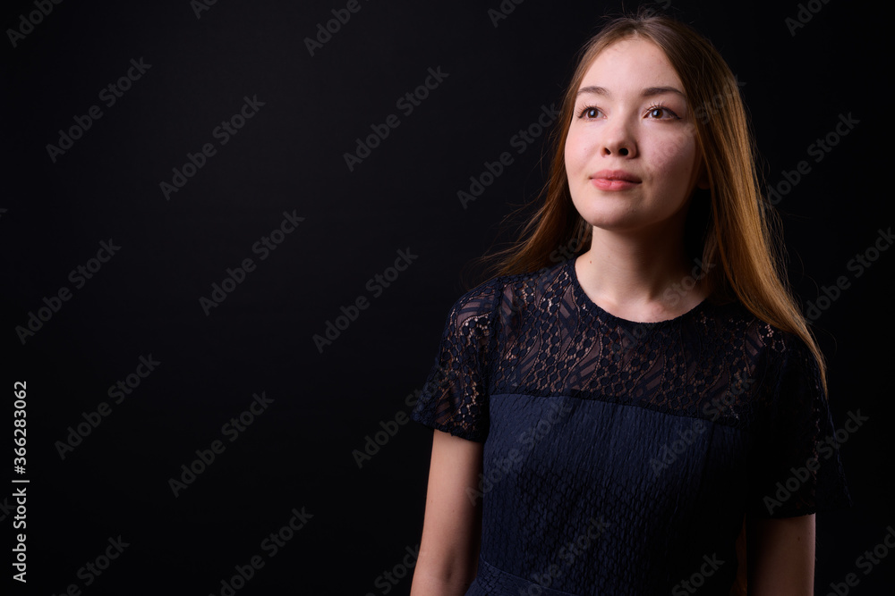 Young beautiful woman with long brown hair against black background Young beautiful woman with long brown hair against black background