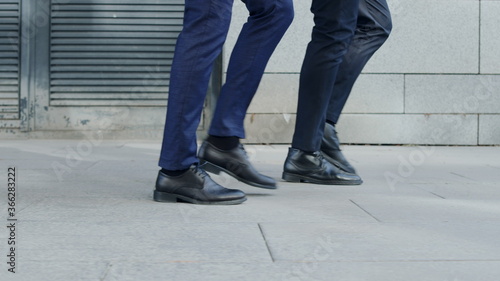Unrecognizable businessmen taking walk on road. Business people going for job © stockbusters