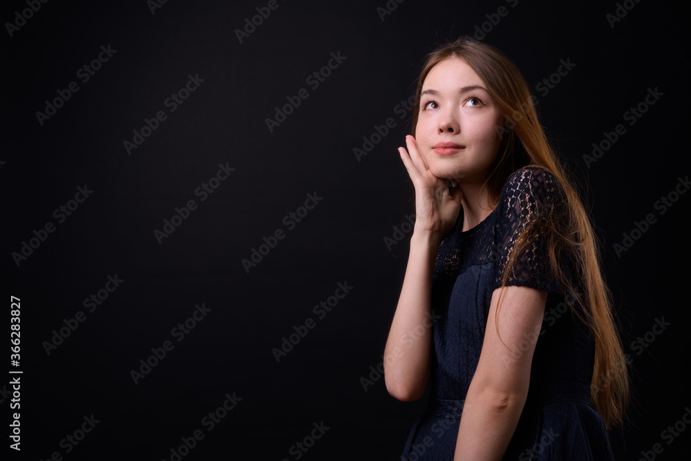 Young beautiful woman with long brown hair against black background Young beautiful woman with long brown hair against black background