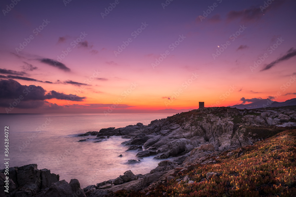 Dawn breaking behind genoese tower in Corsica Dawn breaking behind genoese tower in Corsica