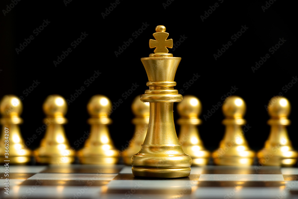 Gold king chess piece stand in front of pawn on black background (Concept of leadership, management)