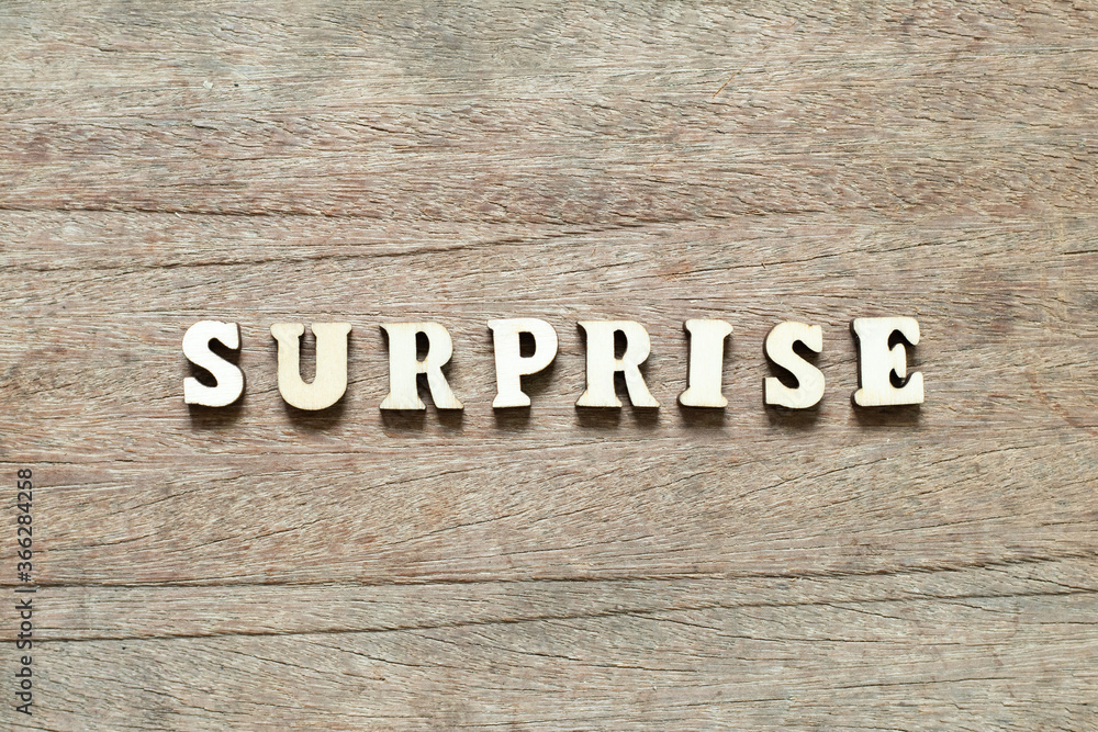 Alphabet letter block in word surprise on wood background