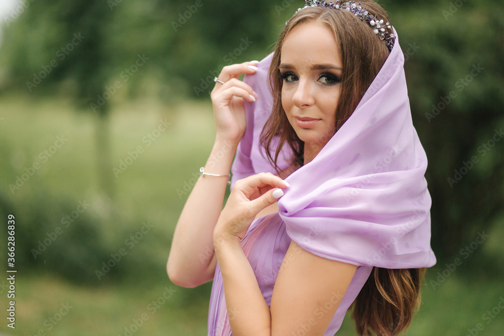 Young woman in elegant evening dress with hood, outdoors