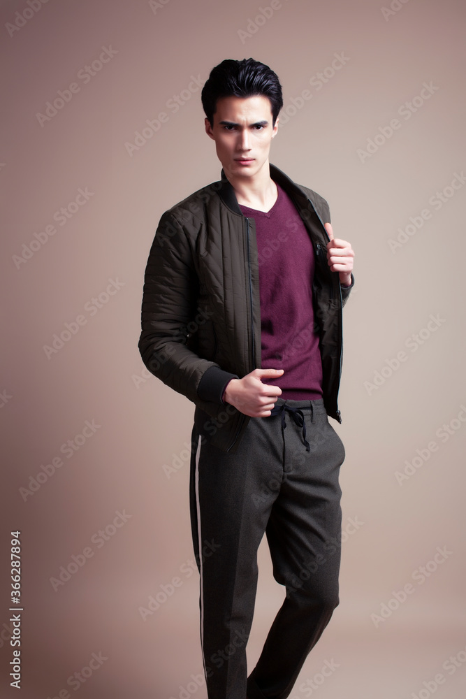 young pretty asian man posing in fashion style on light brown background, lifestyle people concept young pretty asian man posing in fashion style on light brown background, lifestyle people concept