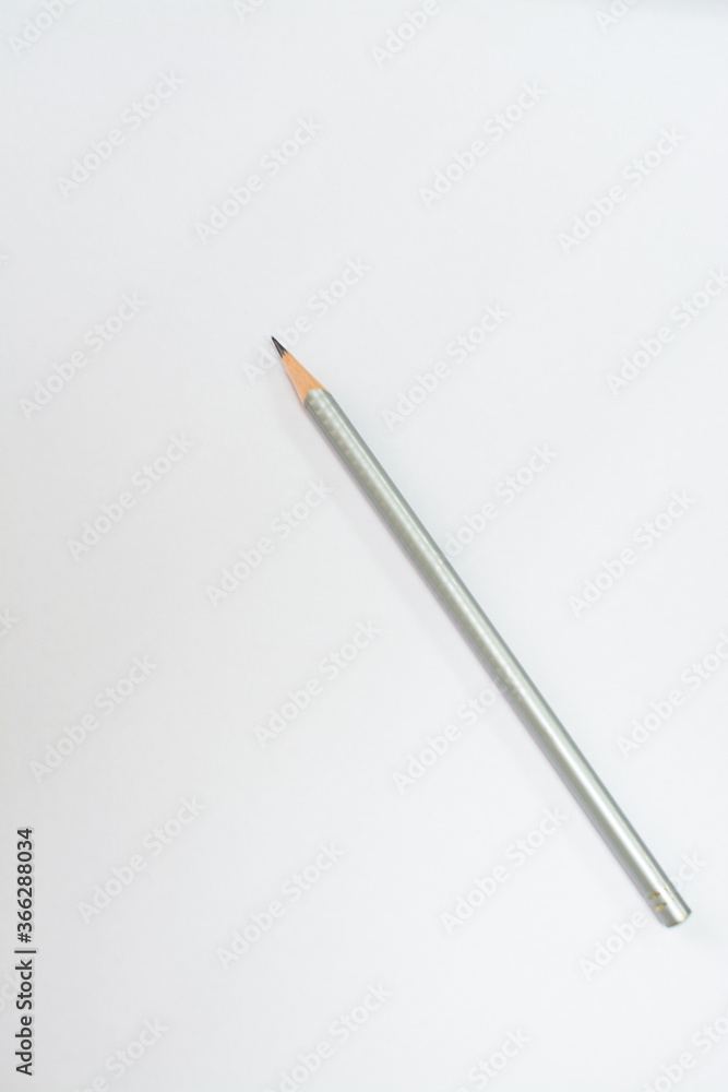 Gray pencil on a white sheet of paper. Place for text. Gray pencil on a white sheet of paper. Place for text.