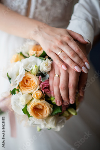 wedding rings on the hands of the newlyweds