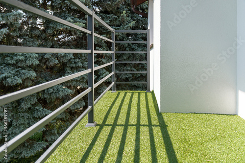 Leinwand Poster balcony railing with a synthetic grass
