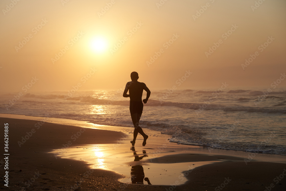 A man running in the morning along the coast of the sea