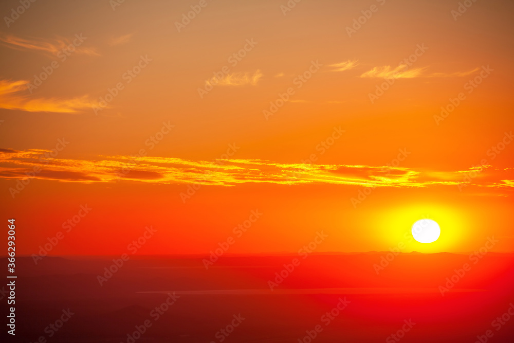 Setting sun over the mountain ridges as a background