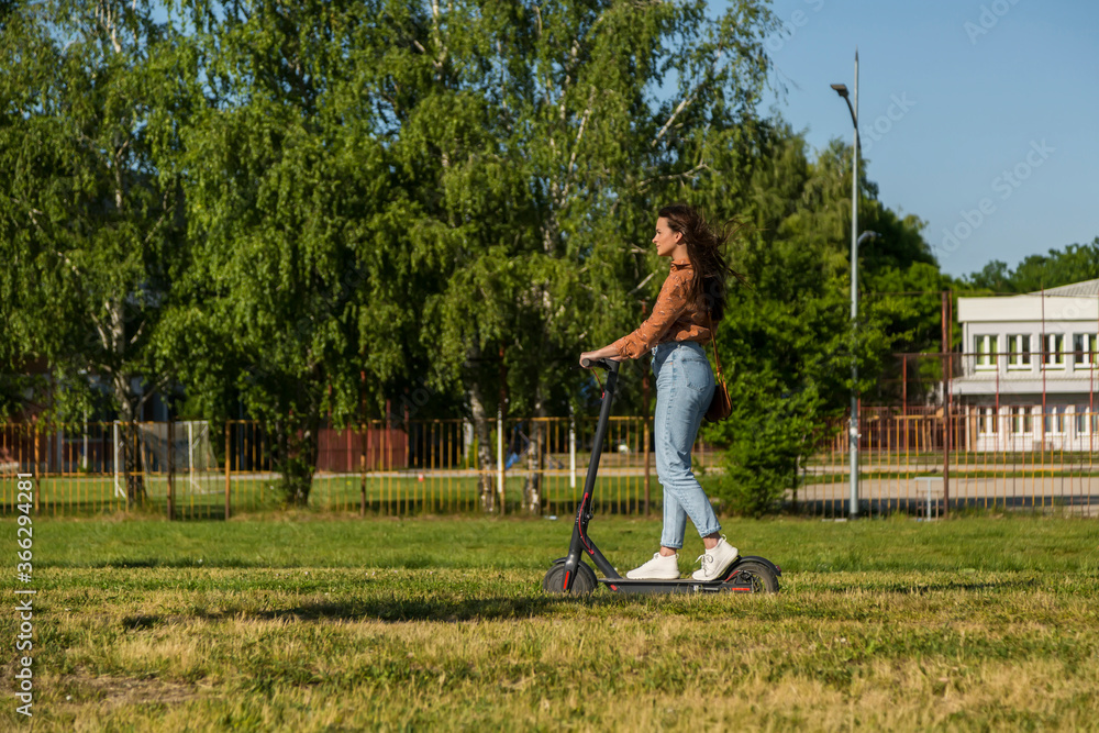 A young woman is driving on an electric scooter A young woman is driving on an electric scooter