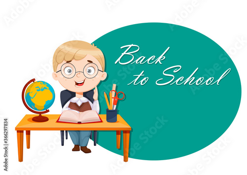 Back to school. Cute schoolboy sits at the desk