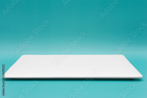 Foto A rectangle empty white plate isolated on the tiffany blue background