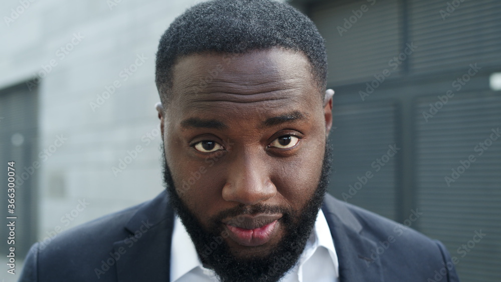 Businessman posing at camera on street. Professional making aggressive grimace Businessman posing at camera on street. Professional making aggressive grimace