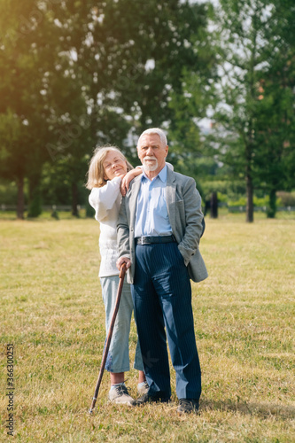 A nice old couple of gray-haired people in the background of the forest. Grandpa with grandmother in nature