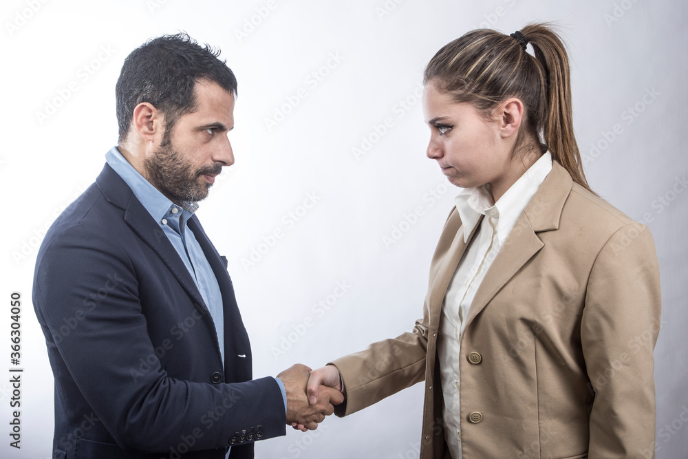 manager bionda da la mano a uomo moro in giacca scura , isolati su sfondo bianco manager bionda da la mano a uomo moro in giacca scura , isolati su sfondo bianco