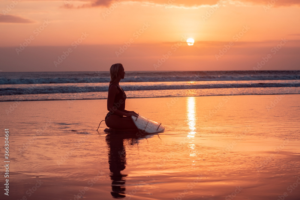 Portrait of surfer girl with beautiful body on the beach with surfboard at colourful sunset time Portrait of surfer girl with beautiful body on the beach with surfboard at colourful sunset time