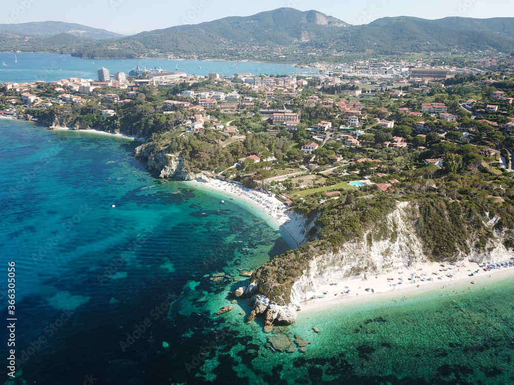 Drone view of Elba island northern coastline. Portoferraio and its white cliffs beaches. Capo Bianco. Italy