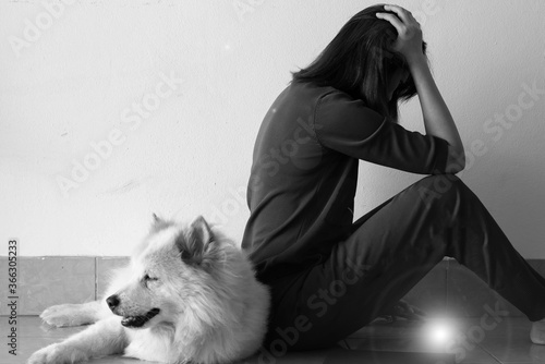 Lady sitting beside her dog with unhappy feeling,stress and upset,Lens flare effect,black and white tone