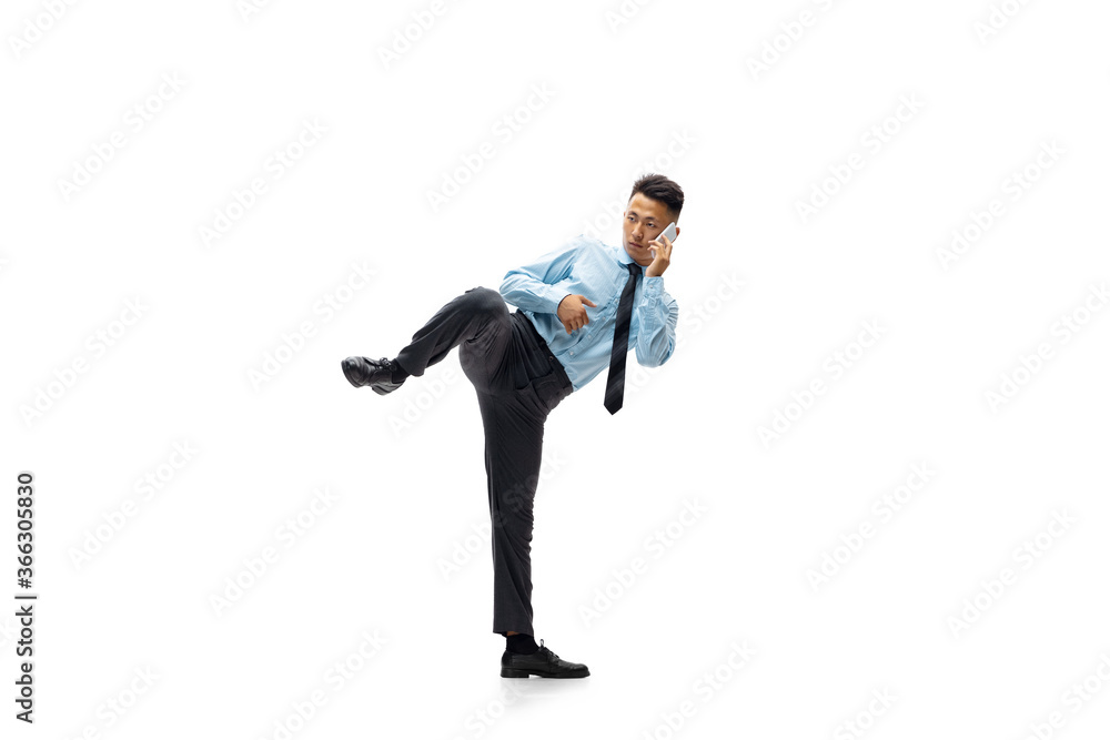 Punch. Man in office clothes practicing taekwondo on white background like professional player, sportsman. Unusual look for businessman in motion, action with ball. Sport, healthy lifestyle Punch. Man in office clothes practicing taekwondo on white background like professional player, sportsman. Unusual look for businessman in motion, action with ball. Sport, healthy lifestyle