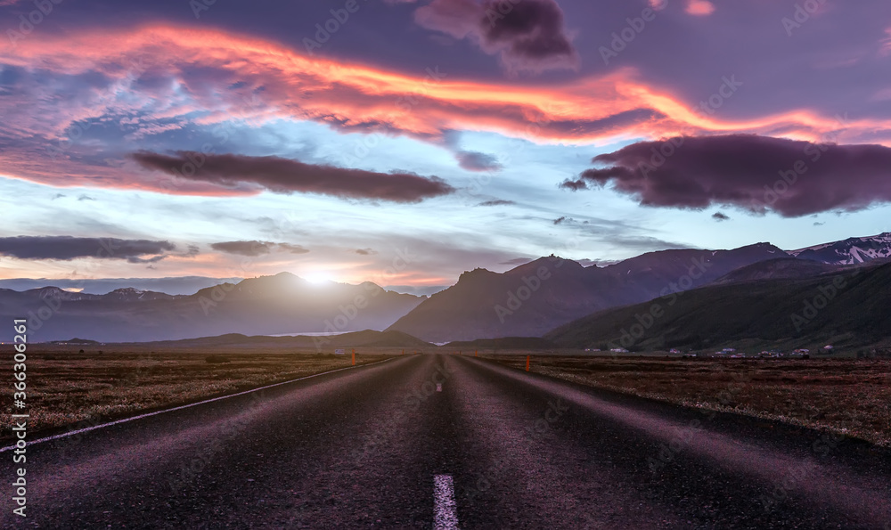 Wonderful picturesque Scene. Typical Icelandic landscape with asphalt road and colorful sdramatic sky during sunset. Impressive nature of Iceland. Travel adventure and freedom concept.
