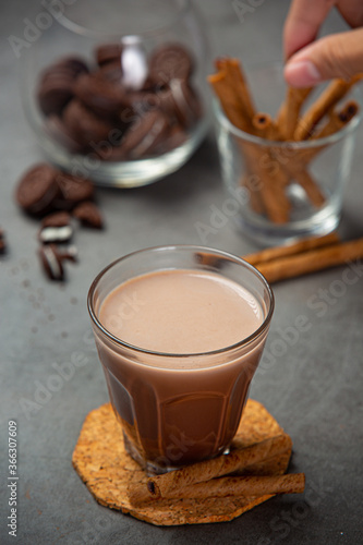 Cocoa served with a delicious chocolate dessert on a black background..