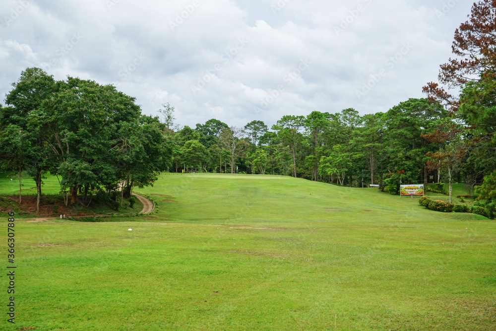 Background of evening golf course has sunlight shining down at golf course in Thailand. Nice scenery on a golf course at a late summer afternoon