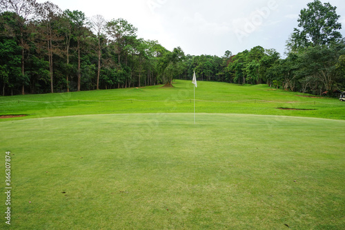 Background of evening golf course has sunlight shining down at golf course in Thailand. Nice scenery on a golf course at a late summer afternoon