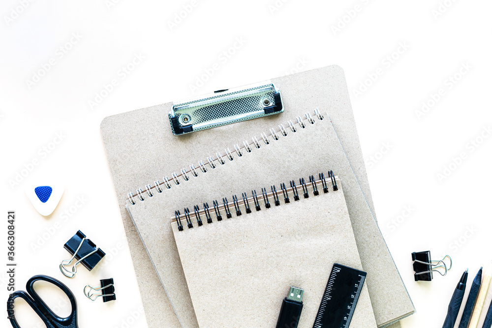 Different stationery for school and office on a white background with copyspace, top view. Different stationery for school and office on a white background with copyspace, top view.