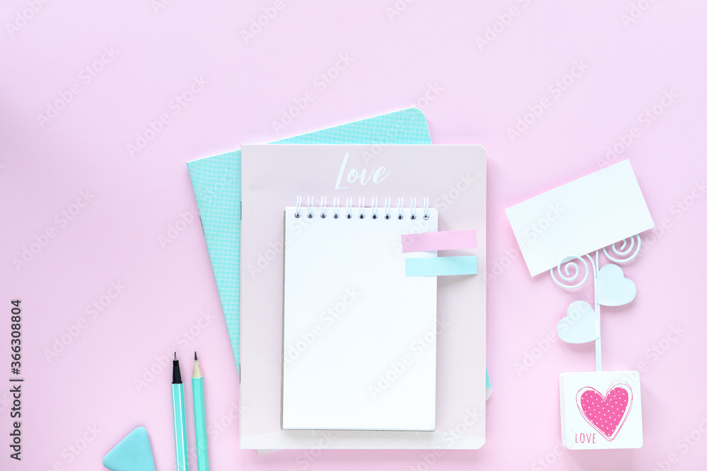 Various colorful stationery for school and office on pink background with copyspace.