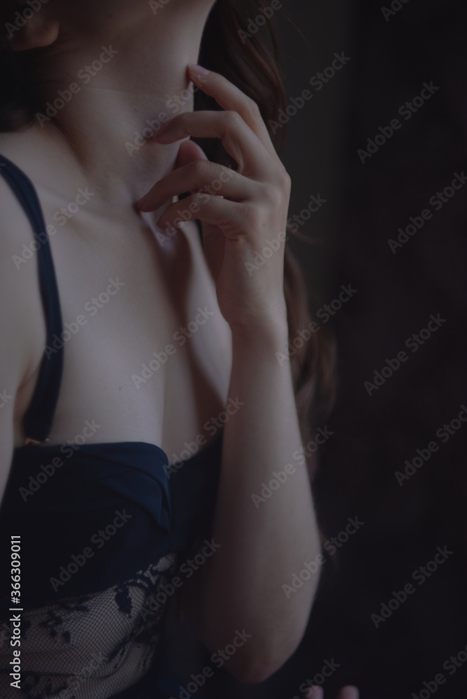 A girl with black hair in black underwear sits on a chair by the window A girl with black hair in black underwear sits on a chair by the window