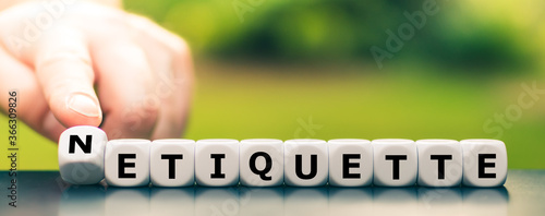 Hand turns dice and changes the word etiquette to netiquette.