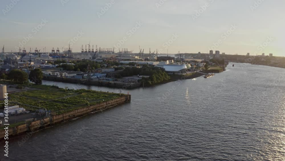 Amazing drone view of wide river and contemporary coastal town Hamburg against sundown sky in evening Amazing drone view of wide river and contemporary coastal town Hamburg against sundown sky in evening