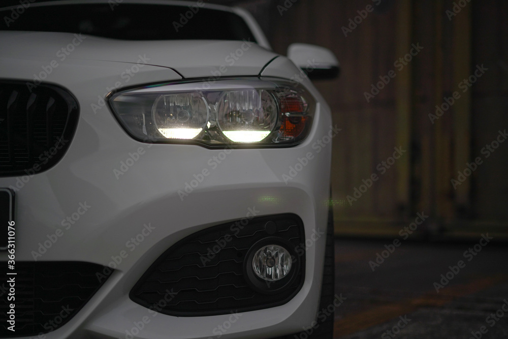 headlights of a white sports car in the dark