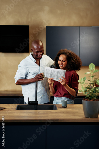 Smiling couple reading a newspaper together