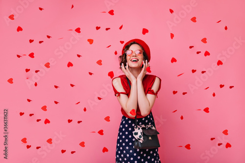 Excited french white woman looking at confetti with sincere smile. Appealing short-haired girl enjoying valentine's day party.