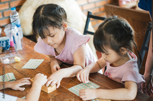 Kids playing board game at their home. Table top game is a good activity for children to learn how to play with others and improve attention and strategy thinking. photo