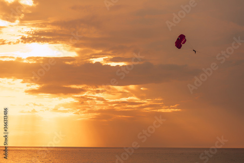 Landscape of orange sunset with parachutist. Naval adventure