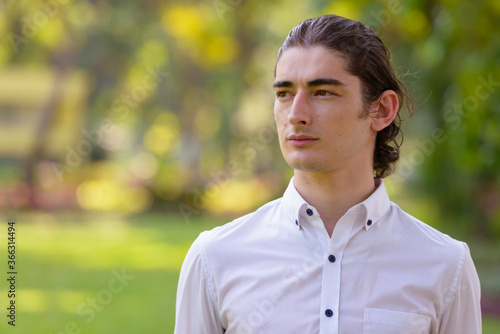 Face of young handsome businessman thinking at the park outdoors